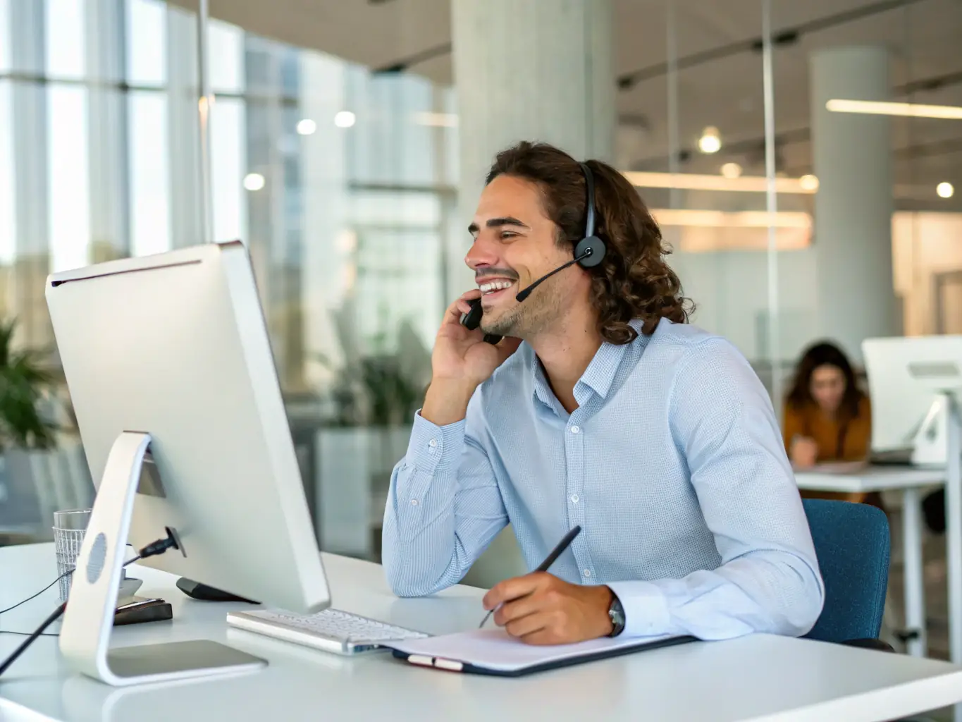 A support staff member at Care Health Solutions answering a phone call, assisting a potential applicant with their questions.